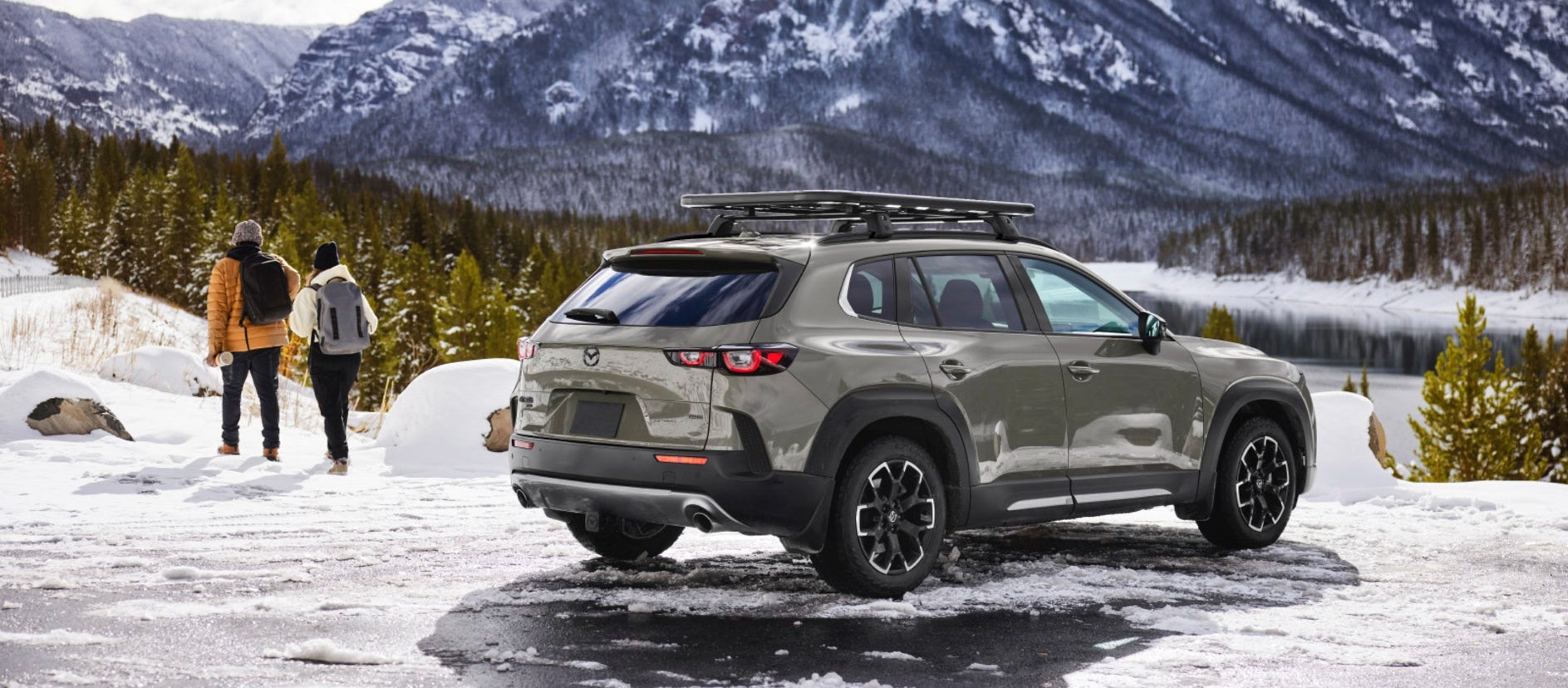 A green Mazda CX-50 parked in a snowy environment.
